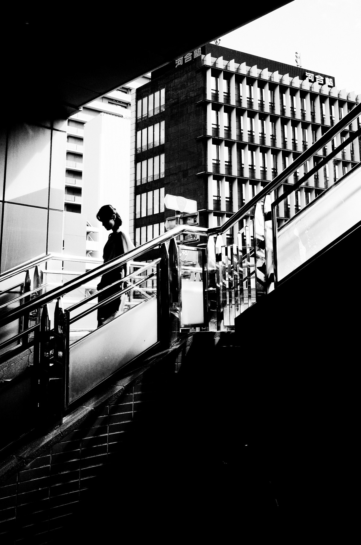 幾何学的な建築と影の中を歩く人