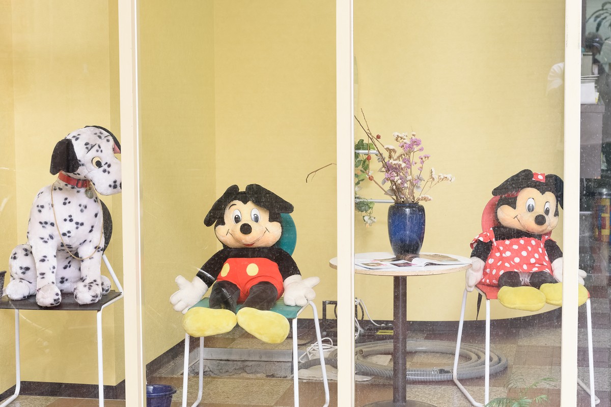店先の椅子に置かれたぬいぐるみと花瓶